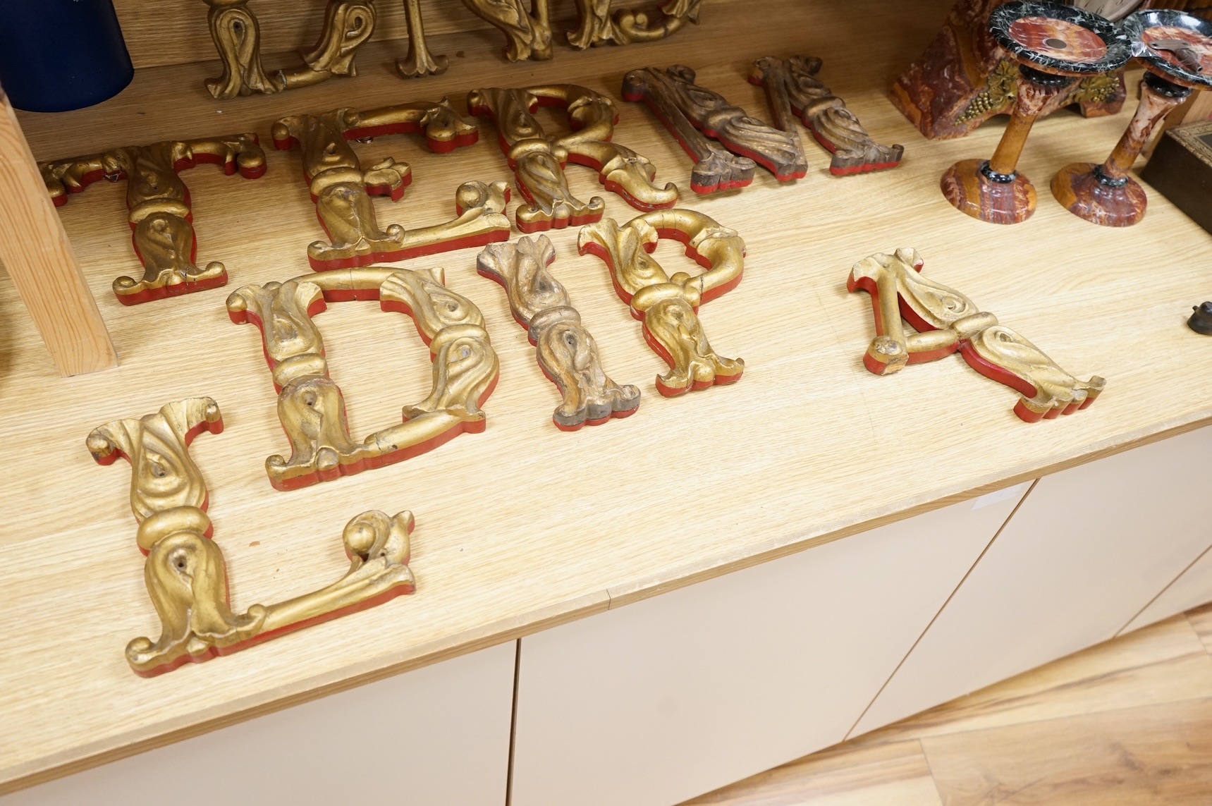 A quantity of decorative carved, painted and gilt carnival letters, each approximately 23cm high